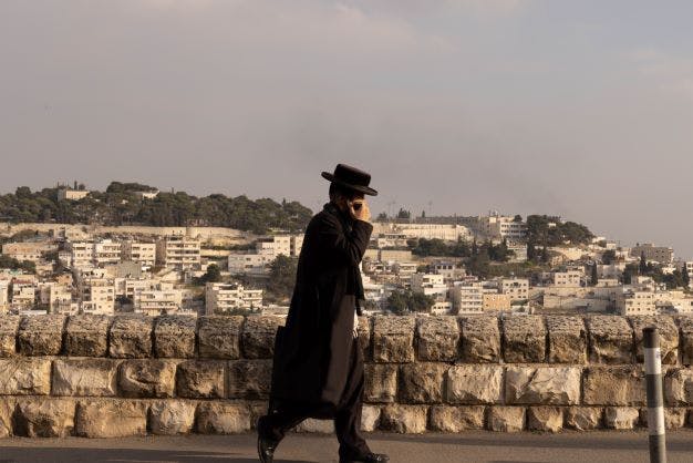 A Haredi Israeli walks along the border between West and East Jerusalem (Deborah Stone)