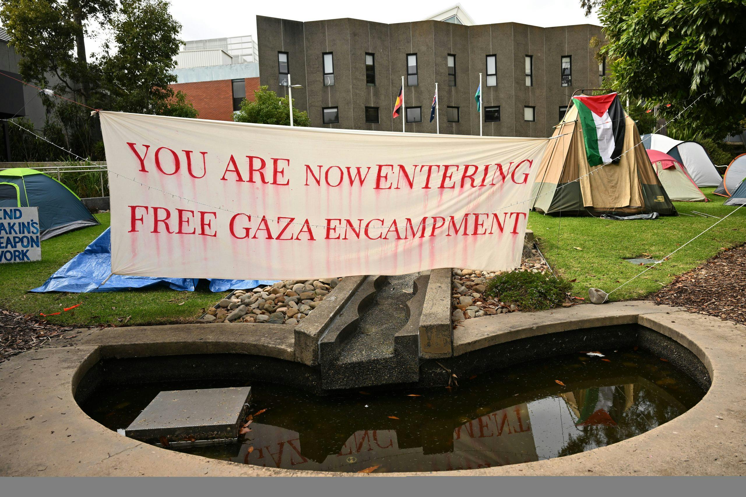 Signage and tents are seen at the Pro Palestine encampment at the Deakin University Burwood campus in Melbourne (Image: AAP Image/James Ross).